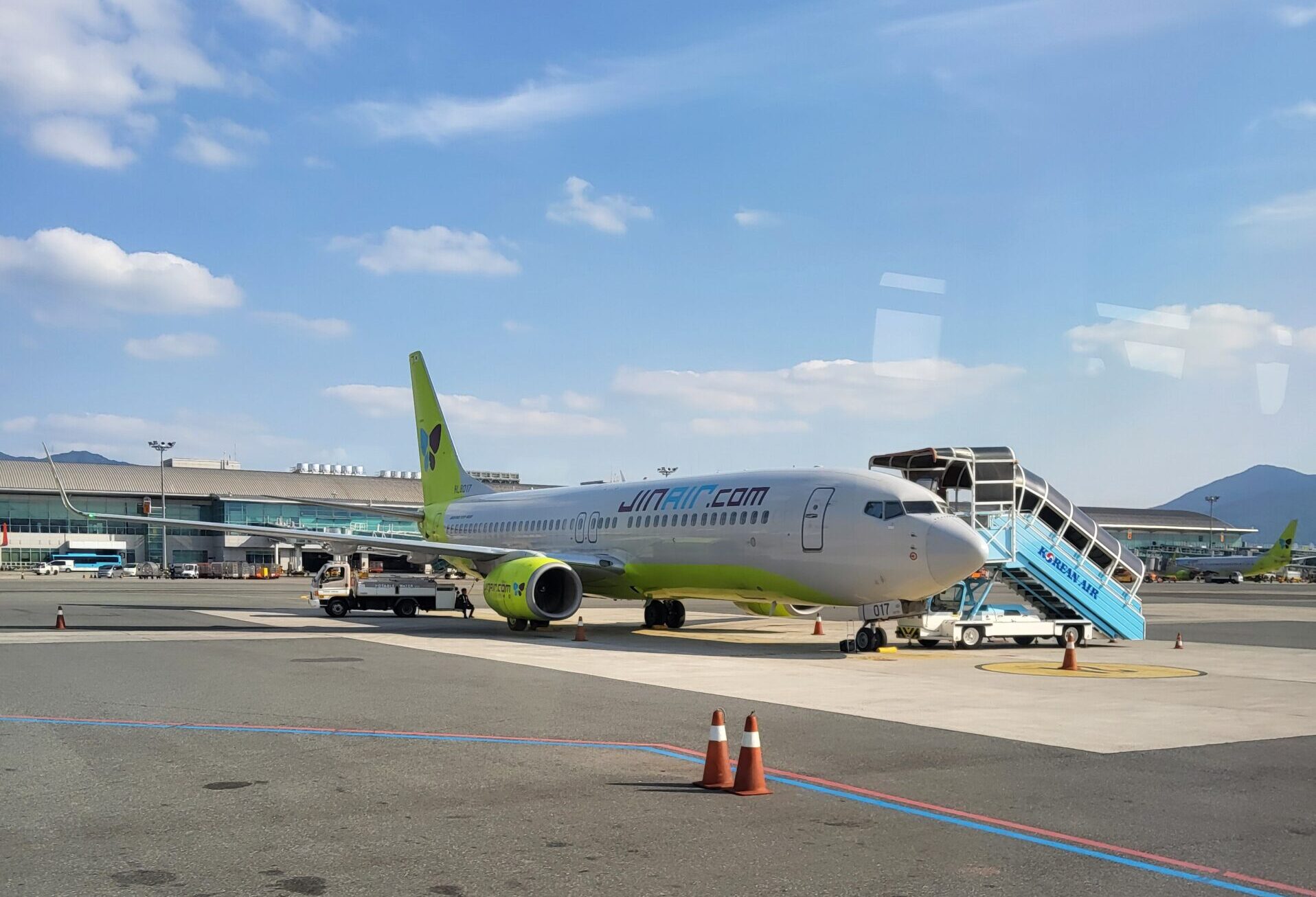 青空の下で搭乗用階段が設置されたジンエアーの機体