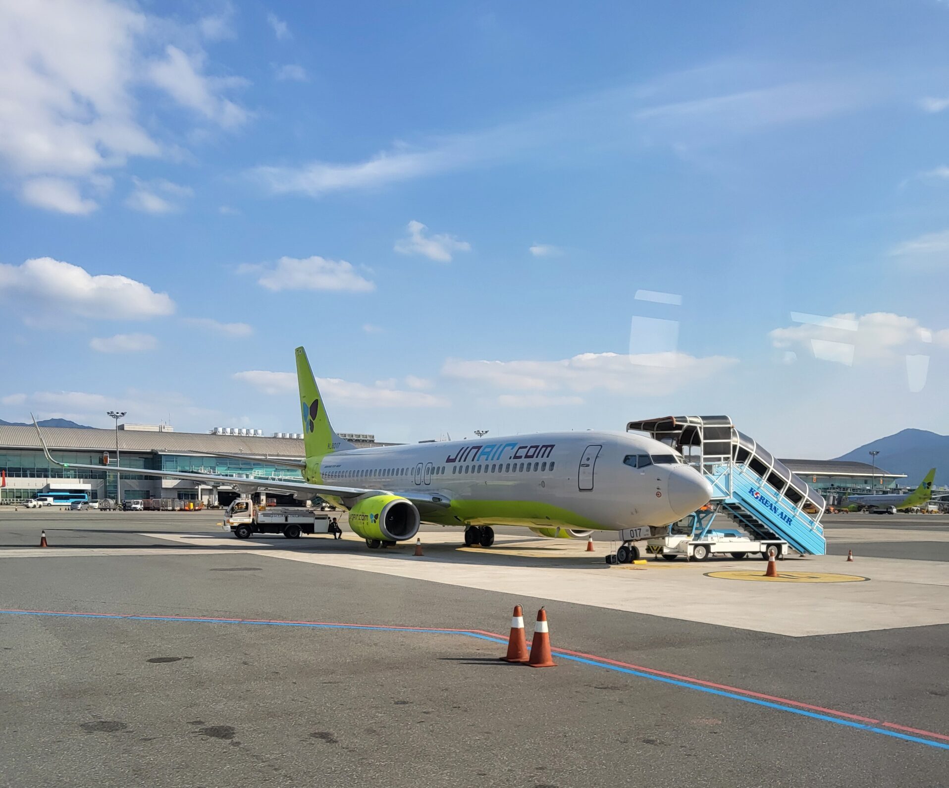 青空の下で搭乗用階段が設置されたジンエアーの機体